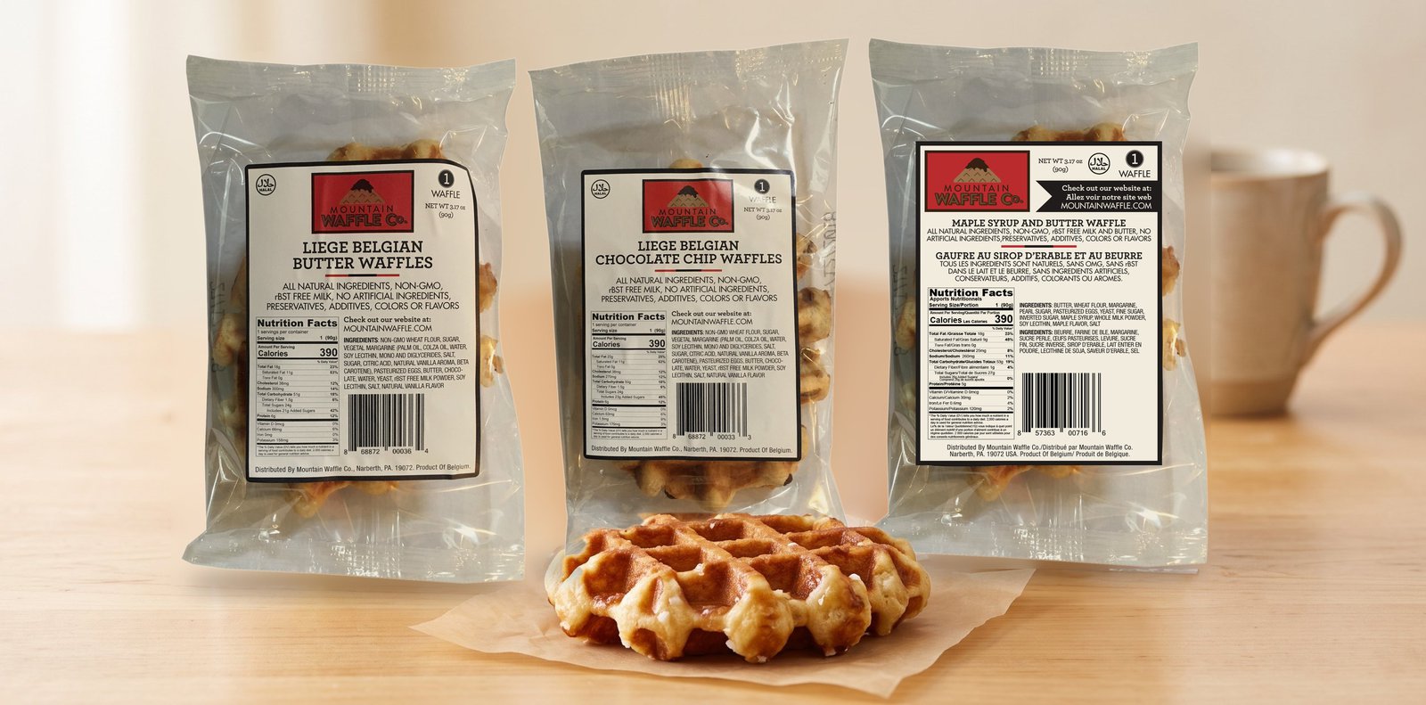 Three individually wrapped Mountain Waffle Co. Liège waffles: Butter, Chocolate Chip, and Maple Syrup & Butter, with an unwrapped waffle in front