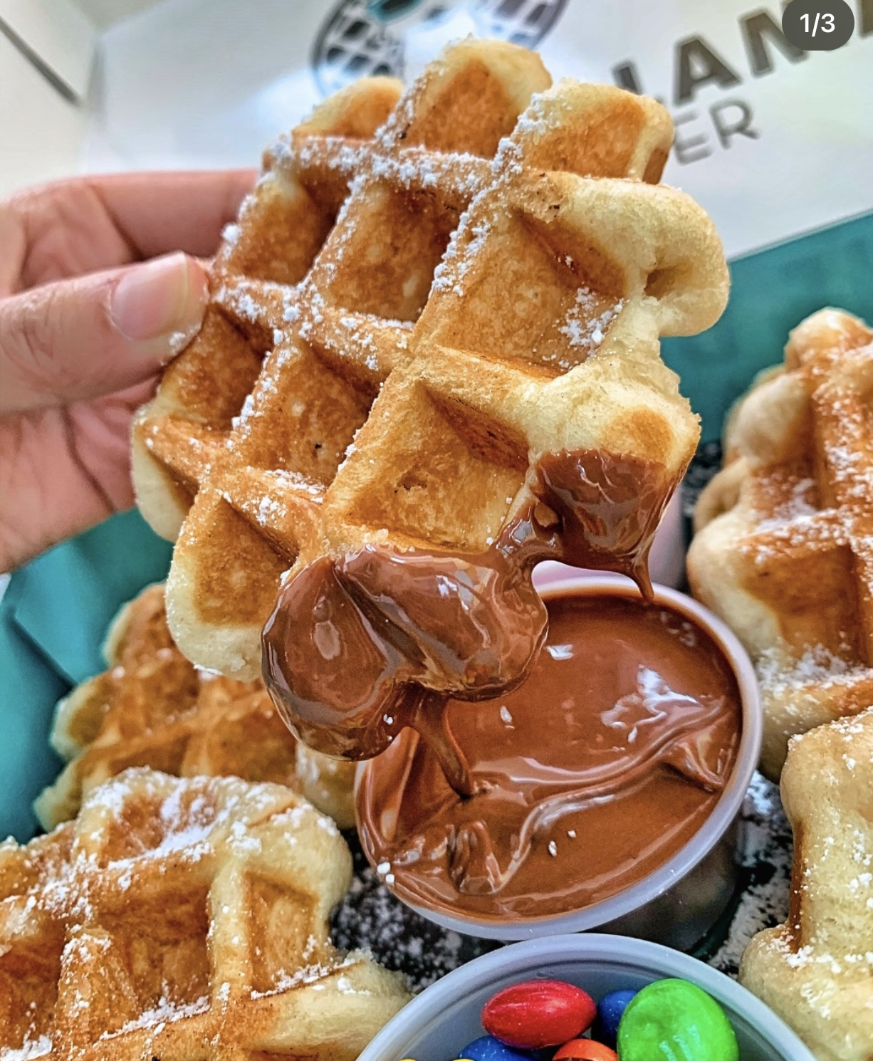 Liège Belgian waffle dusted with powdered sugar, dipped in chocolate spread