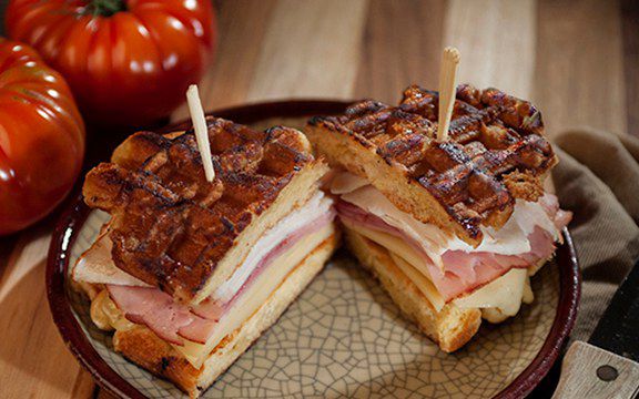 Grilled ham, turkey and Swiss sandwich on Liège waffles, cut in half and held with picks