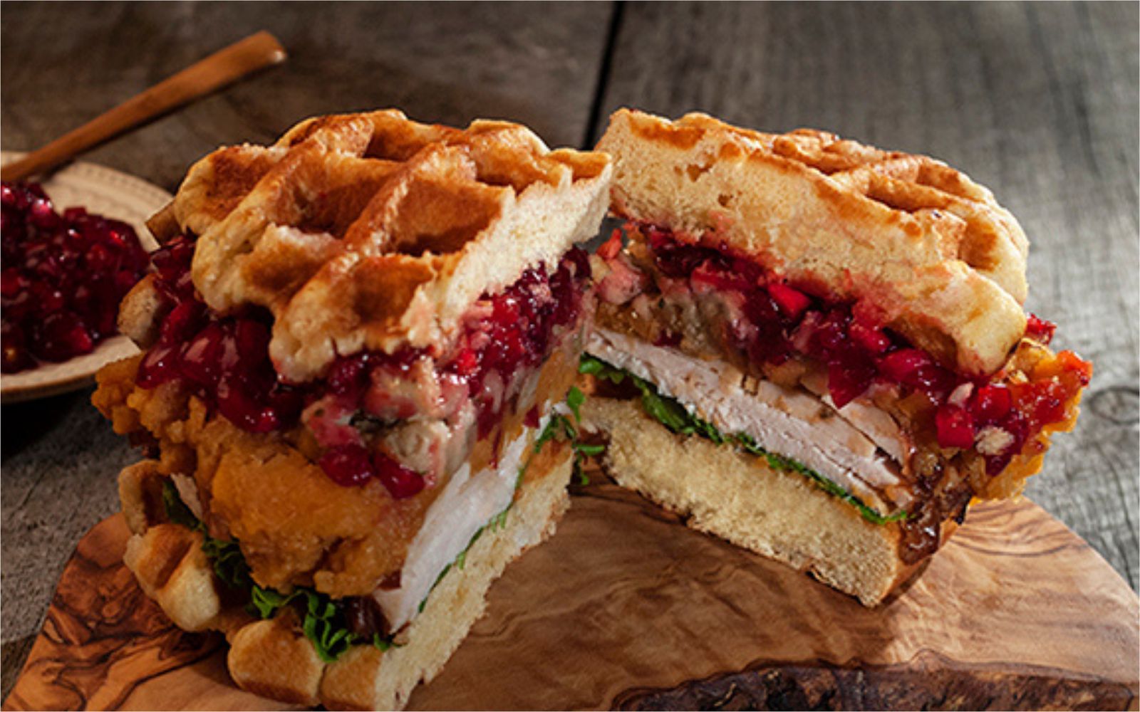 Turkey, stuffing and cranberry sauce stacked between Liège waffles, cut in half to show the layers